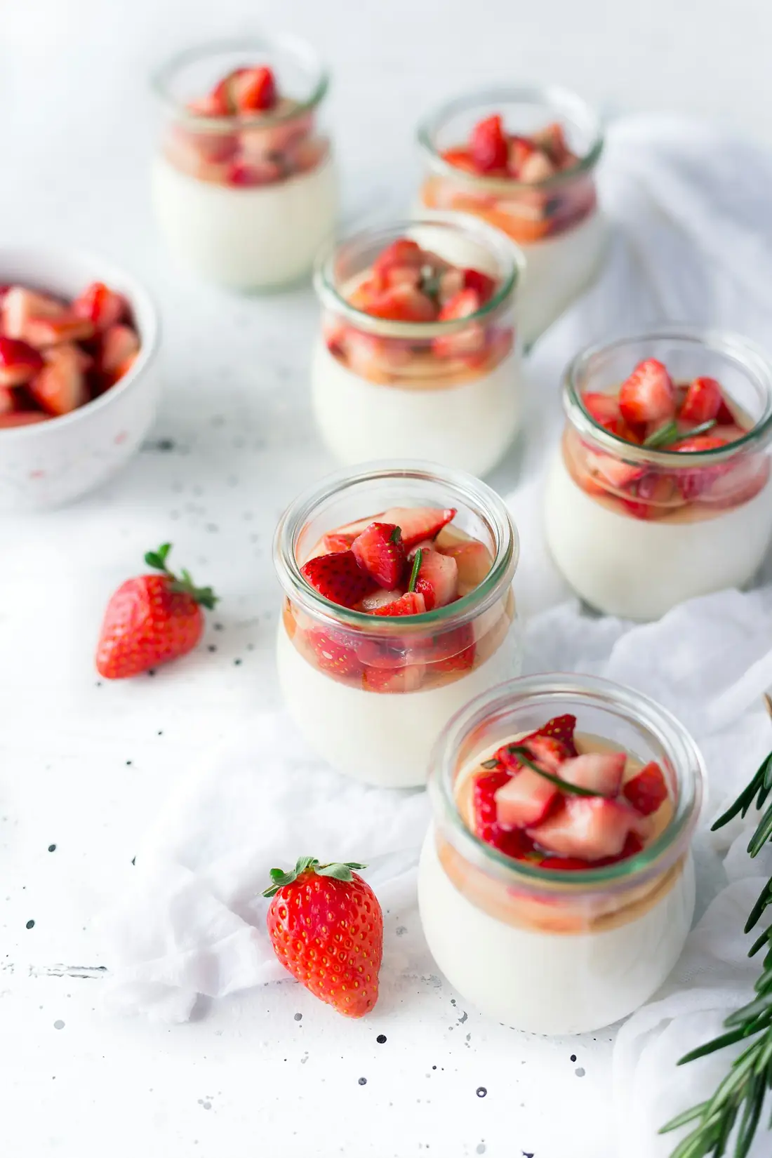 Jars of buttermilk panna cotta topped with macerated strawberries